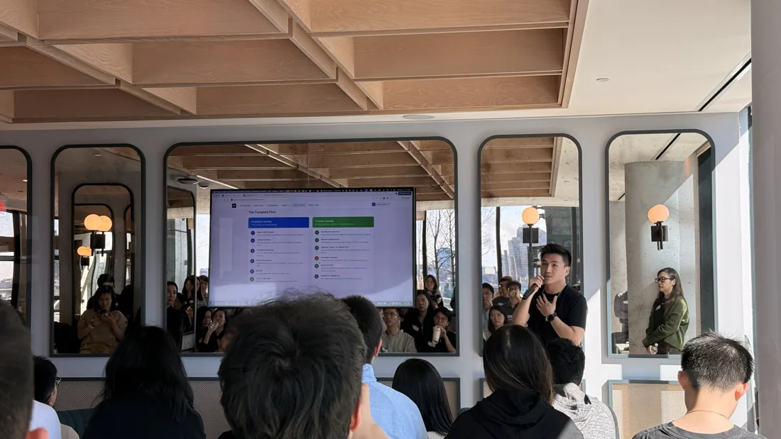 A room of people watching live demos at an AI show-and-tell gathering